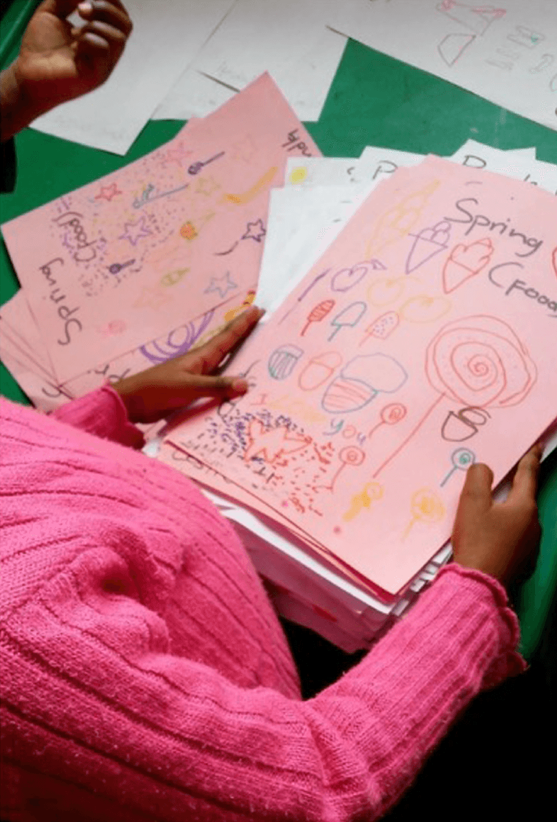 Three Children Sort Through Their Peers Work